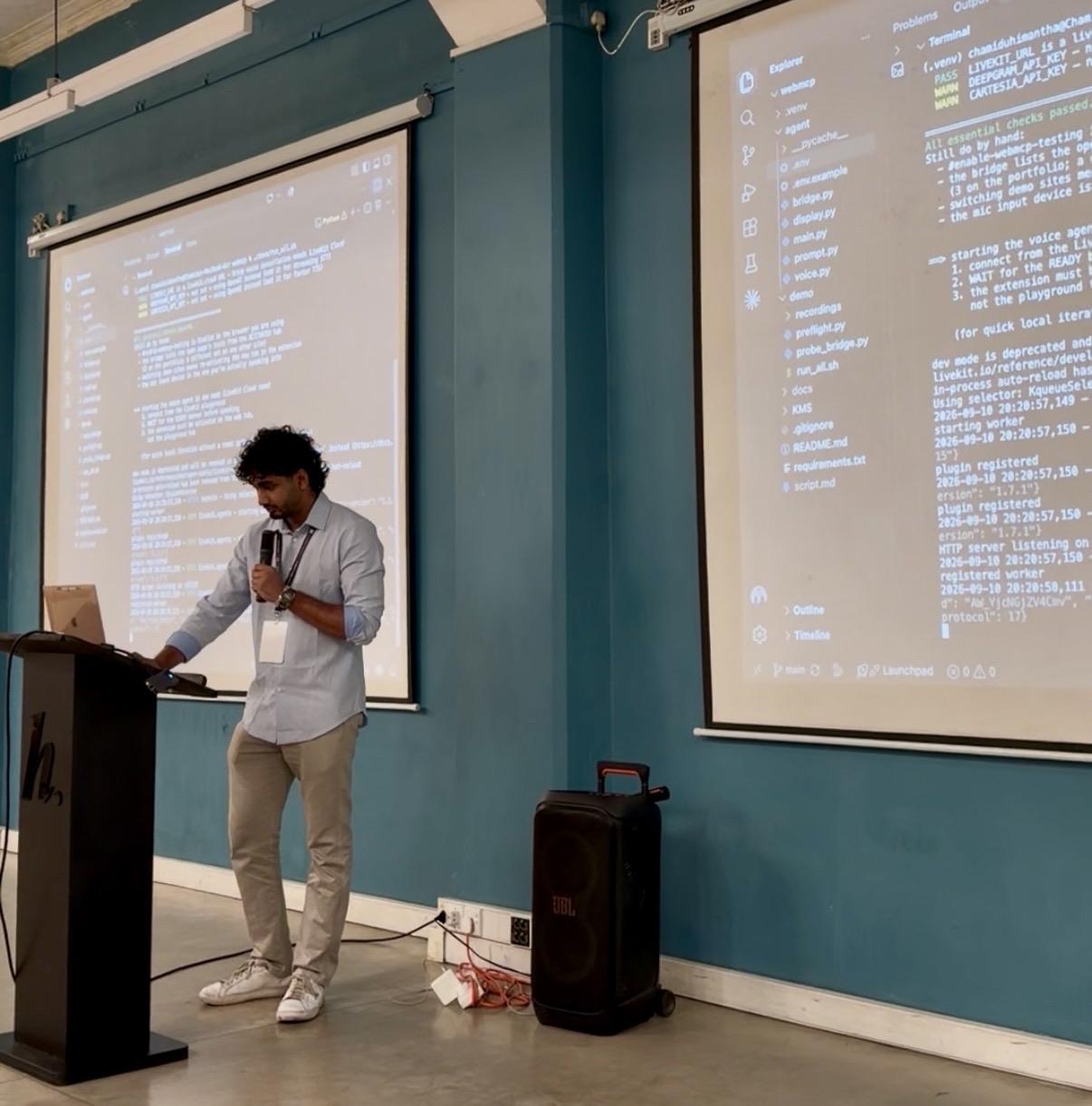 Chamidu at the podium with the live demo’s terminal on two projector screens